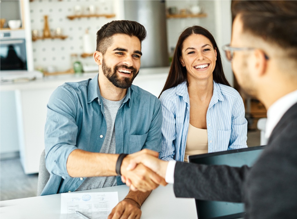 A happy couple shaking hands with their estate planning attorneys