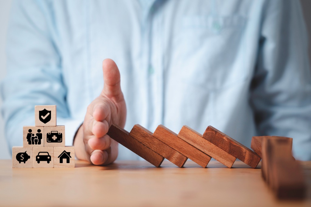 A Florida asset protection attorney using his hand to protect blocks representing various assets from other falling blocks, a visual representation of asset protection