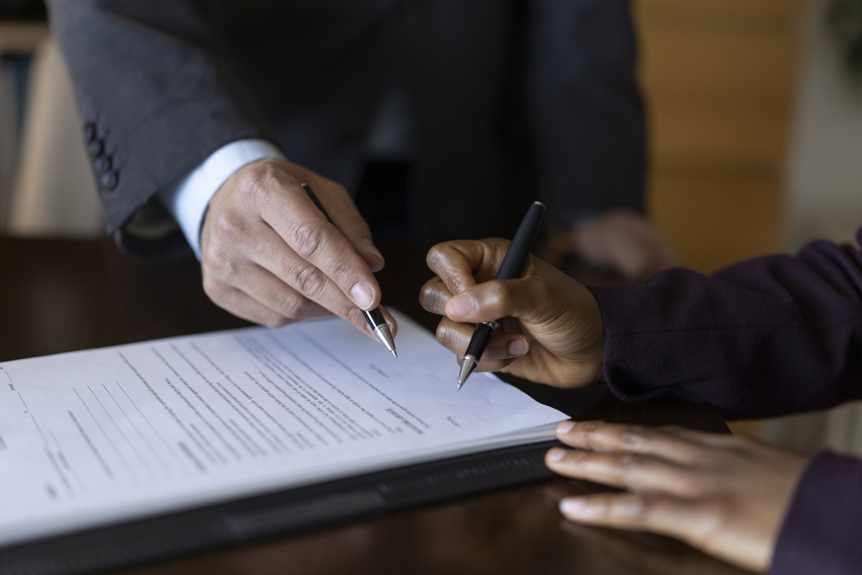 An attorney showing a client where to sign a legal document